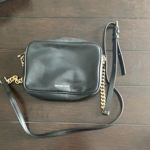 Authentic black Michael Kors crossbody with fun detail on back of purse..see pic